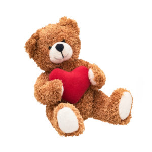 Teddy bear with a red heart isolated over white background. Valentine's Day concept.
