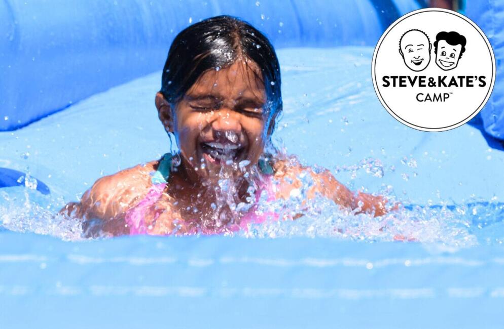 A little girl laughs as she splashes around in the water at Steve & Kate's Camp