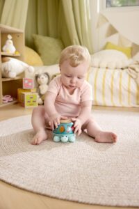 Baby playing with a twist and tune turtle