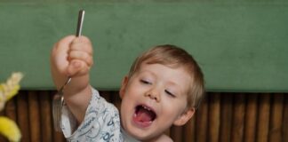 A young boy cheerfully enjoys healthy food at a restaurant.