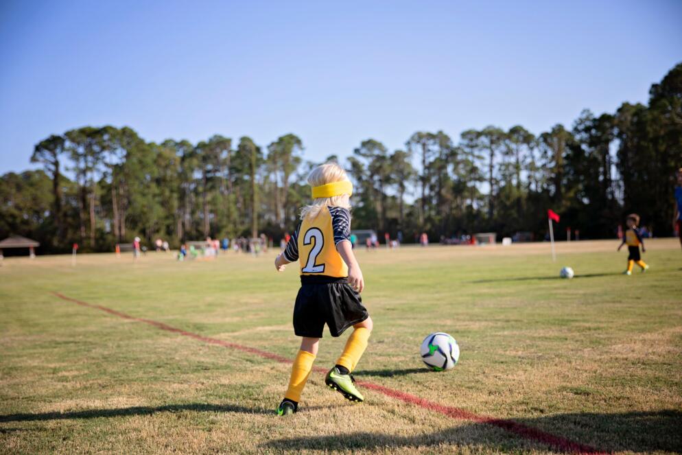 A school-age girl training with a soccer ball
