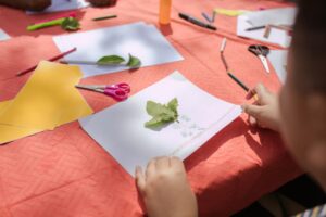 A child making an art project with a leaf