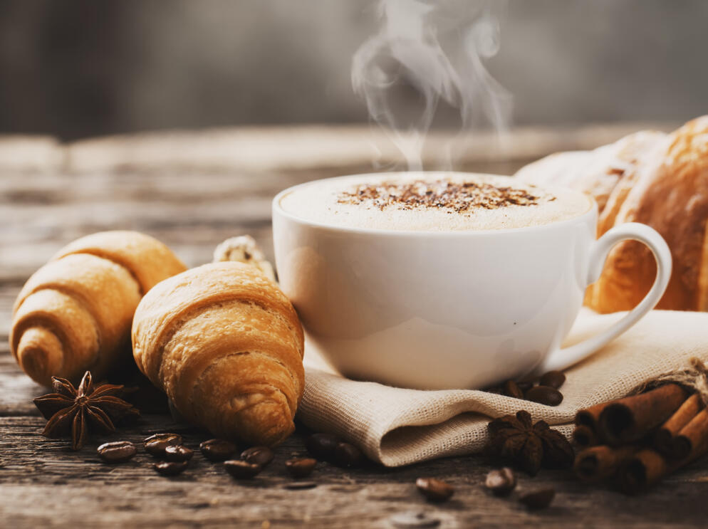 Hot coffee and pastries on a wooden background