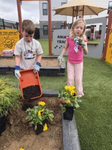 Two children host a newscast for World News Day at The Goddard School